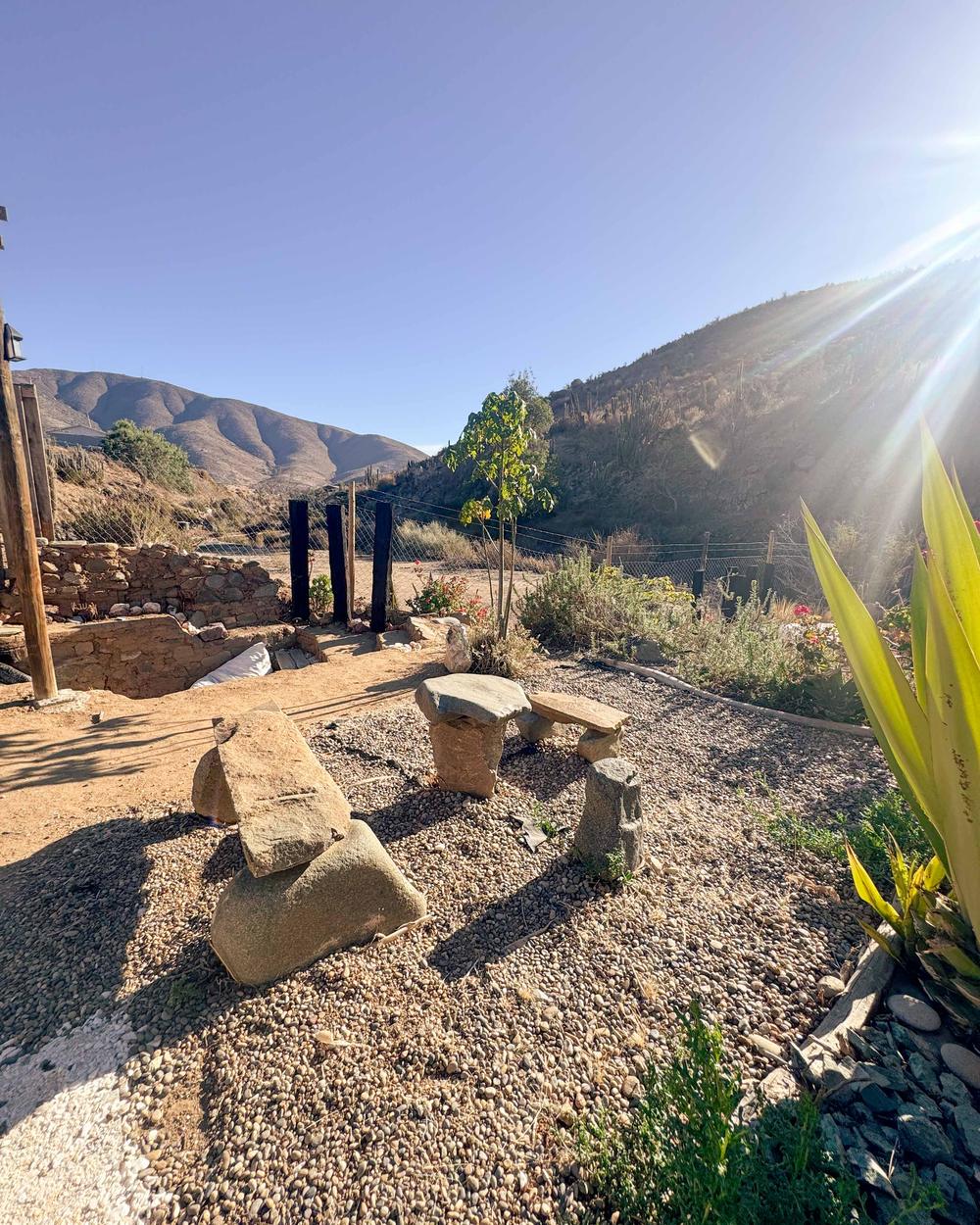 Espacio exterior con bancos de piedra y vista a los cerros de Canela Baja