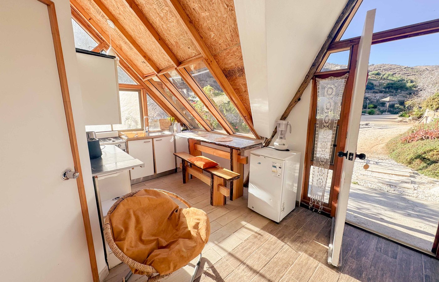Cocina con ventanal inclinado y vista al cerro